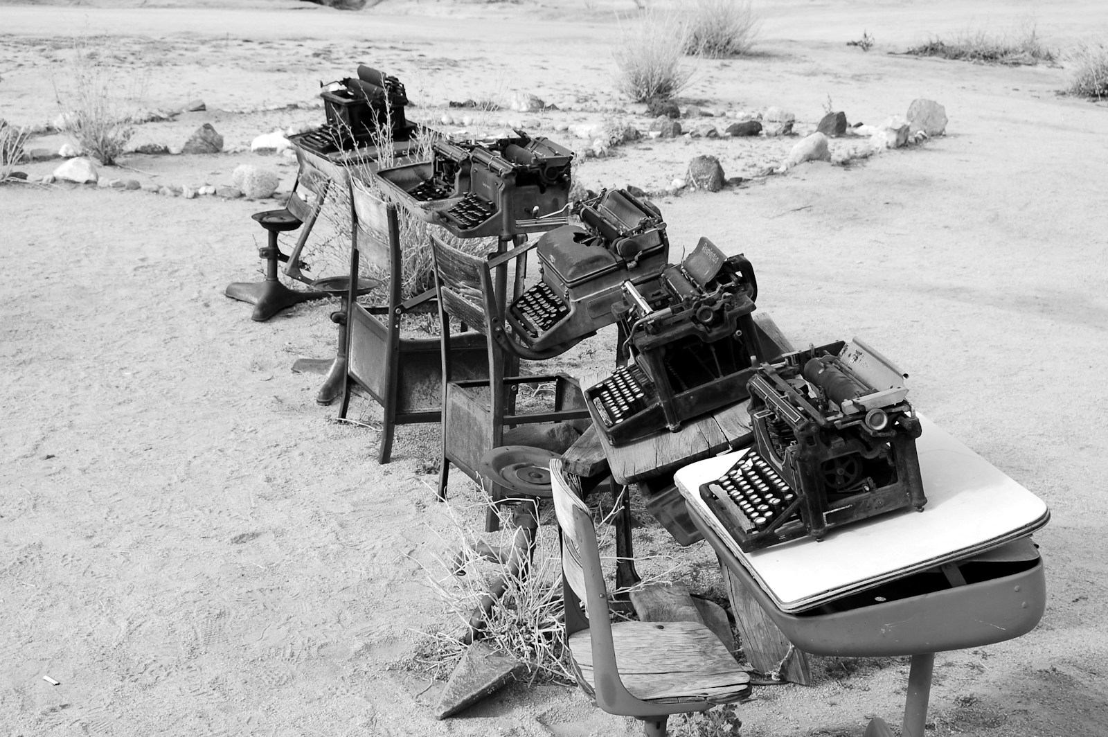 grayscale photo of typewriter on tables